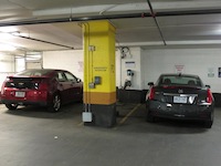 2014 Cadillac ELR Graphite Gray and red chevrolet volt plugged in at a charging station